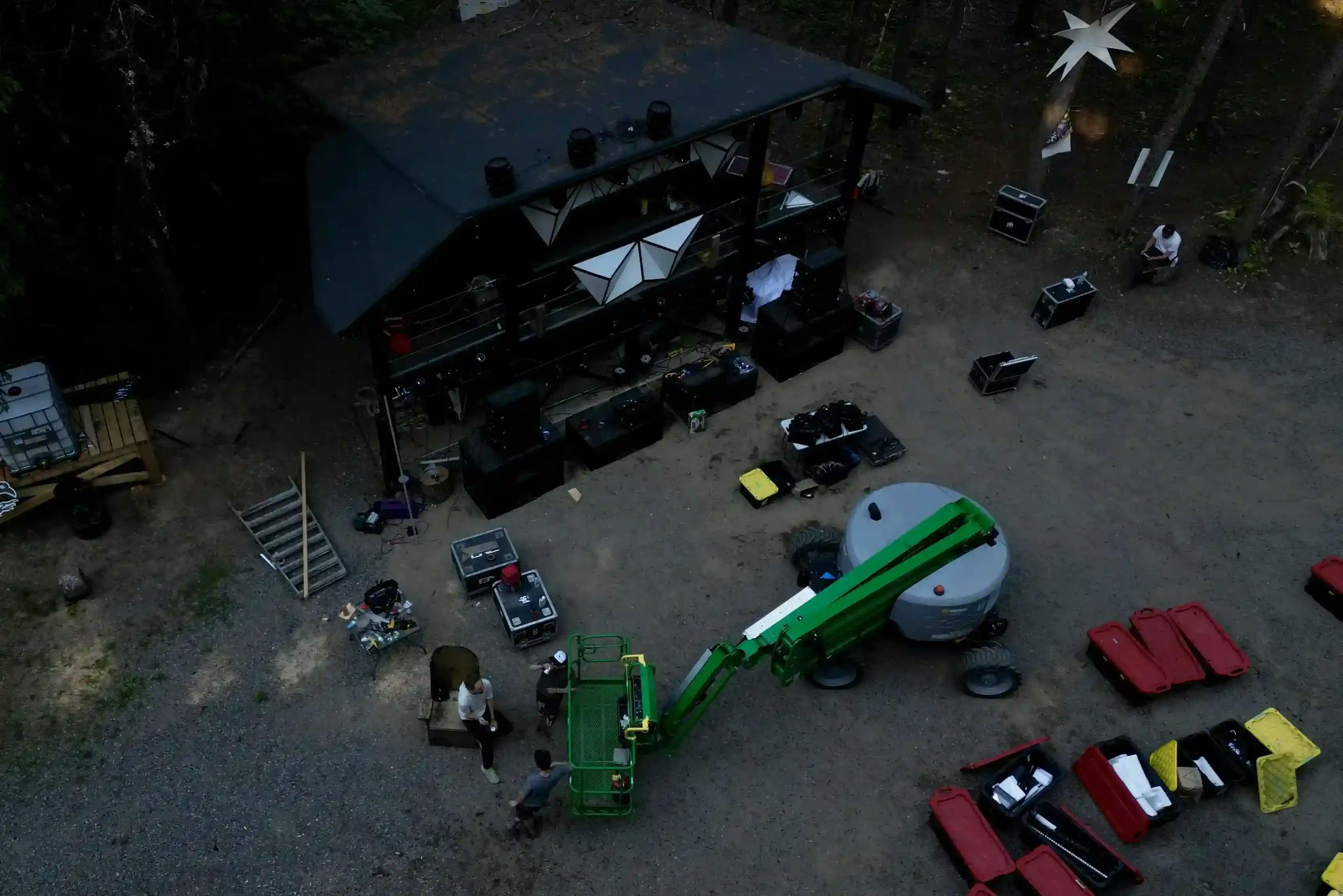 Overhead view of the Asgard stage during setup, with equipment and crew preparing for the festival.