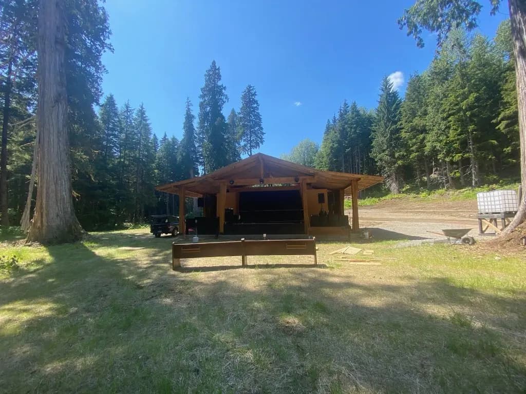 Sunny view of the AgeHa stage at ValhallaFest, set against a backdrop of tall trees.