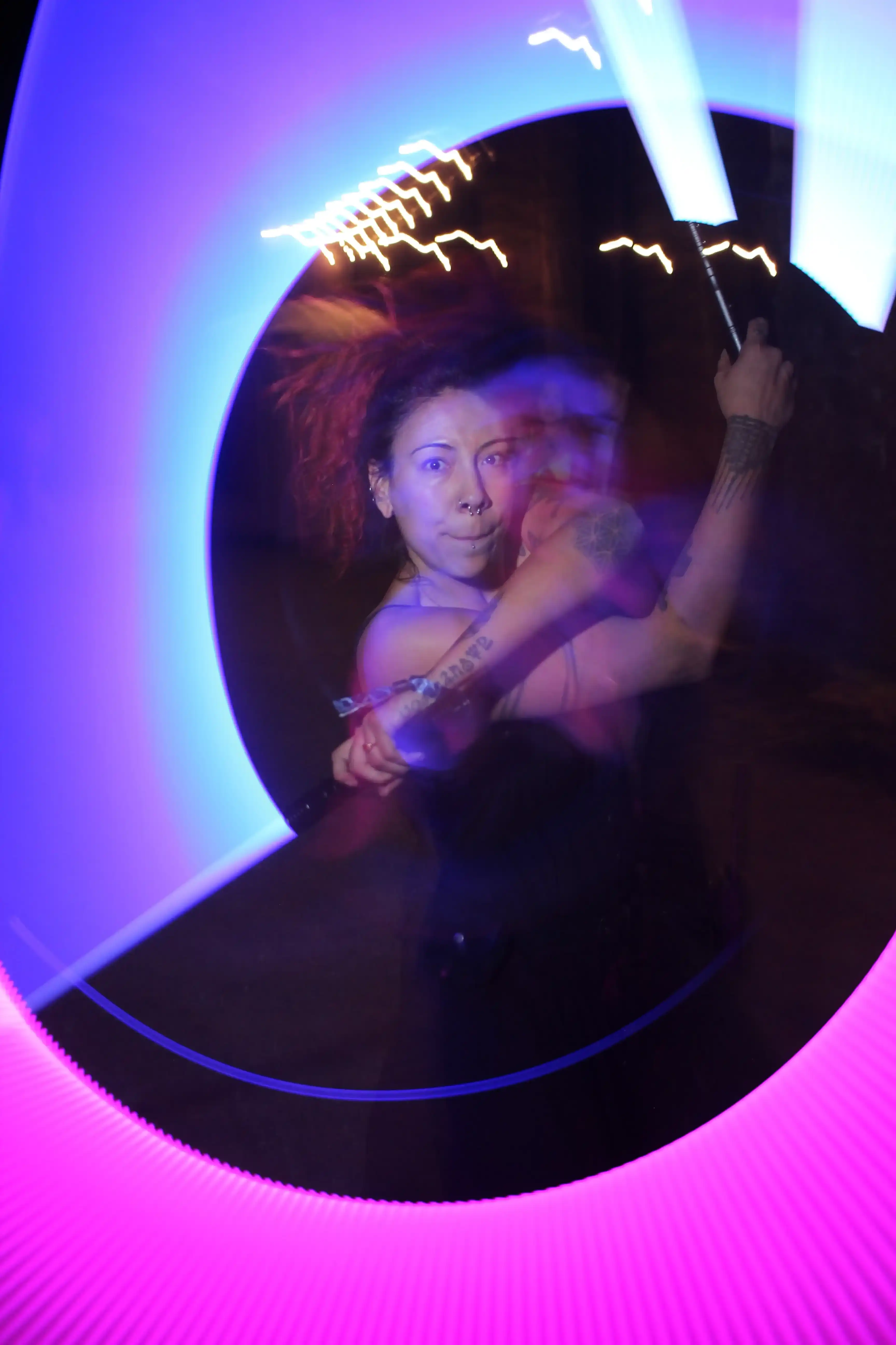 Festival-goer dancing with a light stick at ValhallaFest at night.