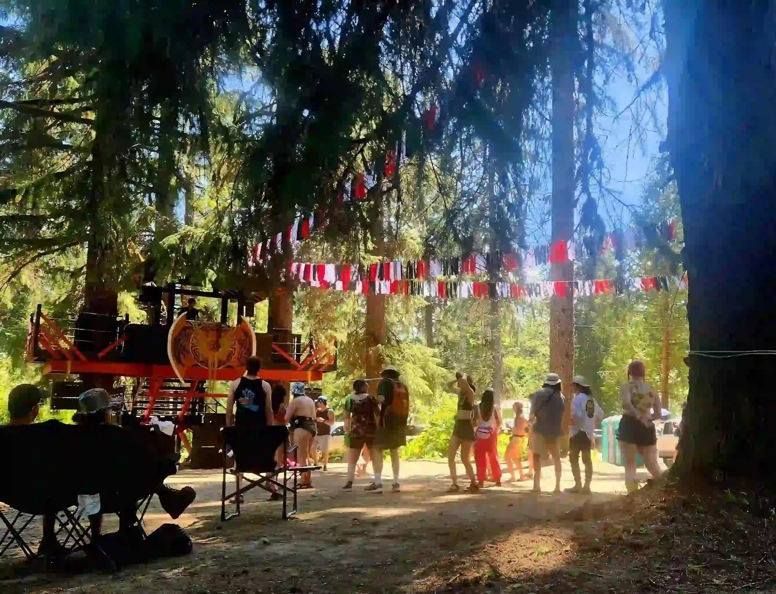 Festival-goers enjoying daytime activities at Leif's Beach stage adorned with festive bunting.