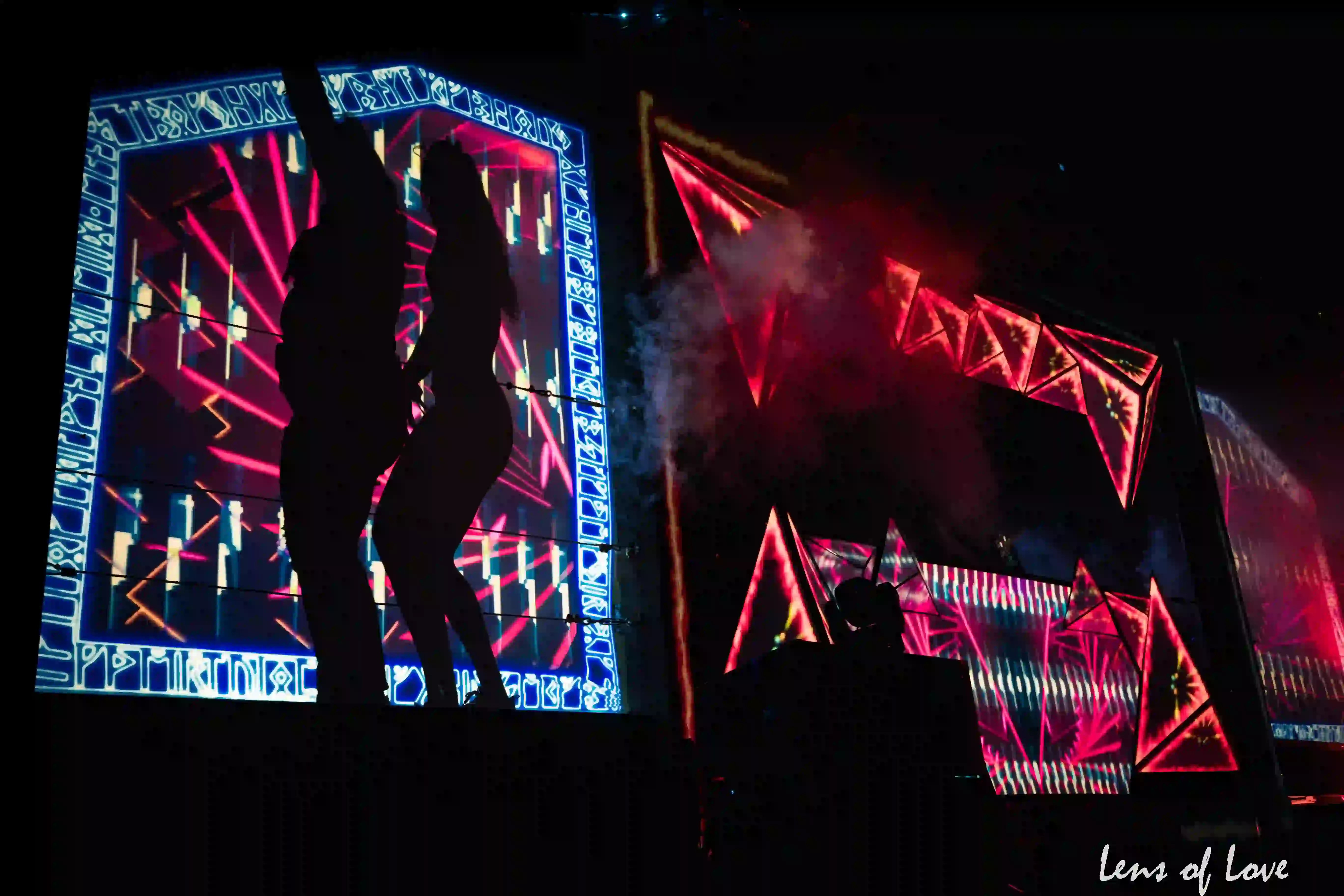 Asgard stage at night with dazzling light shows, lasers, and crowds enjoying the music.