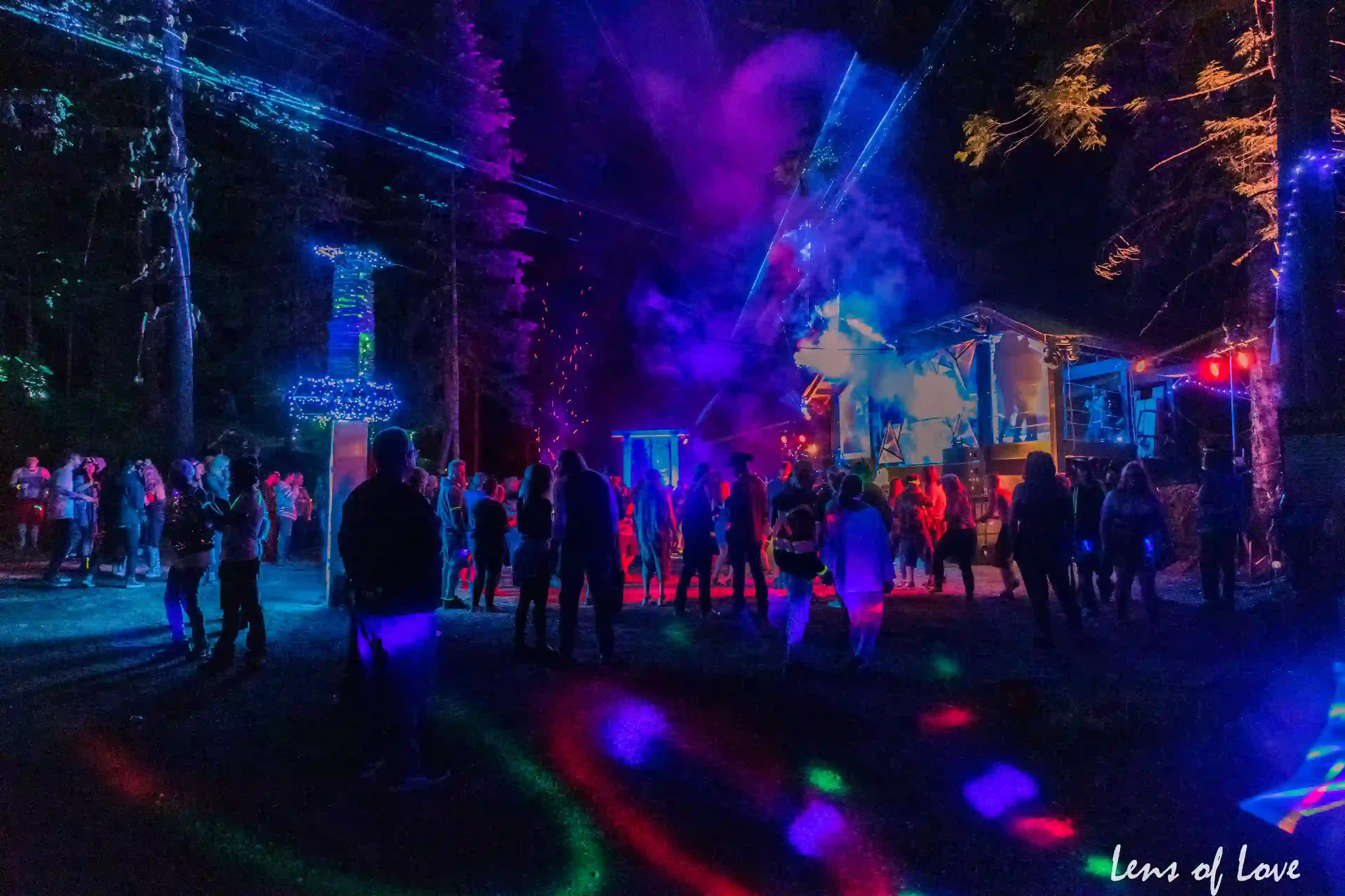 Asgard stage at night with dazzling light shows, lasers, and crowds enjoying the music.