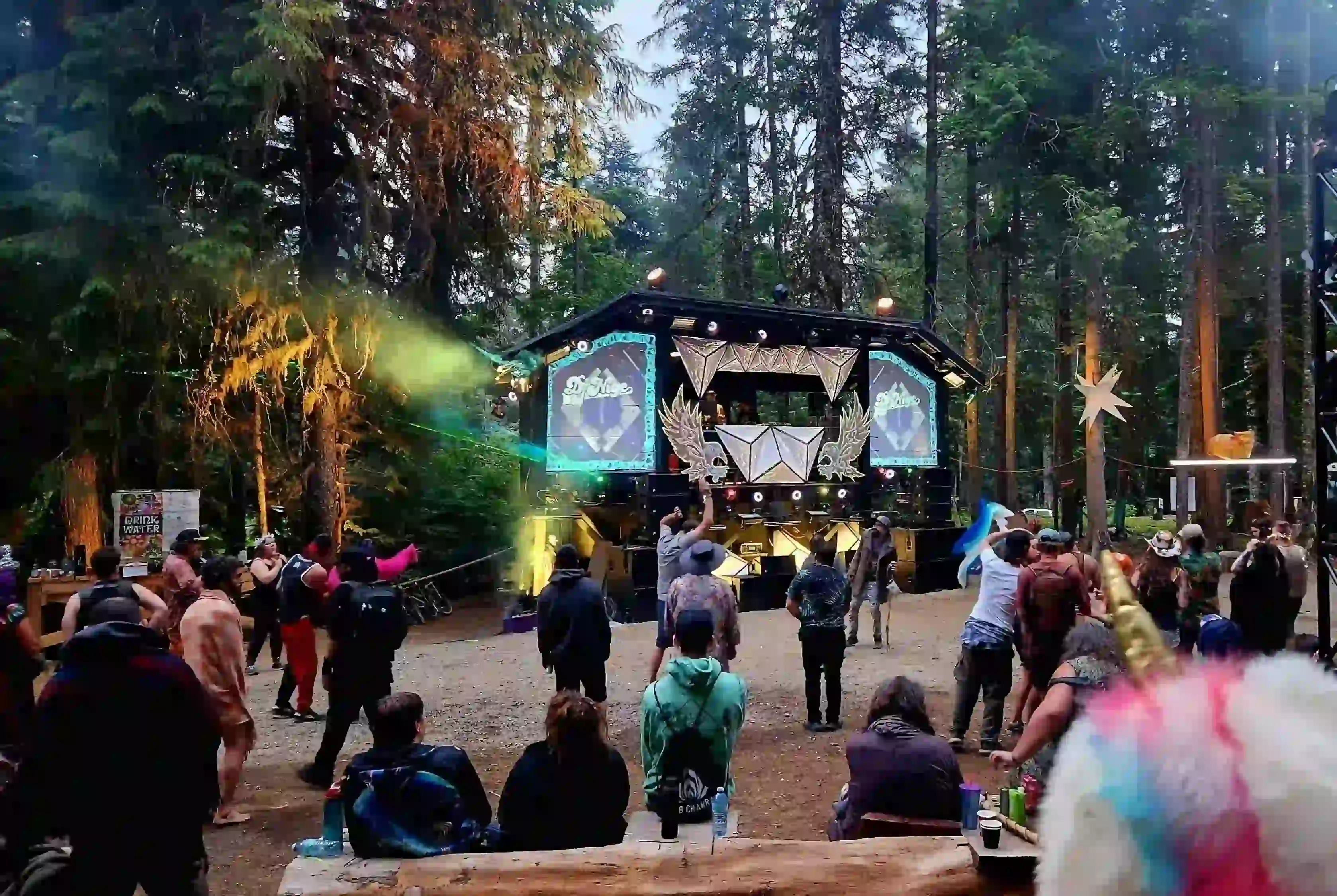 Asgard stage at night with dazzling light shows, lasers, and crowds enjoying the music.